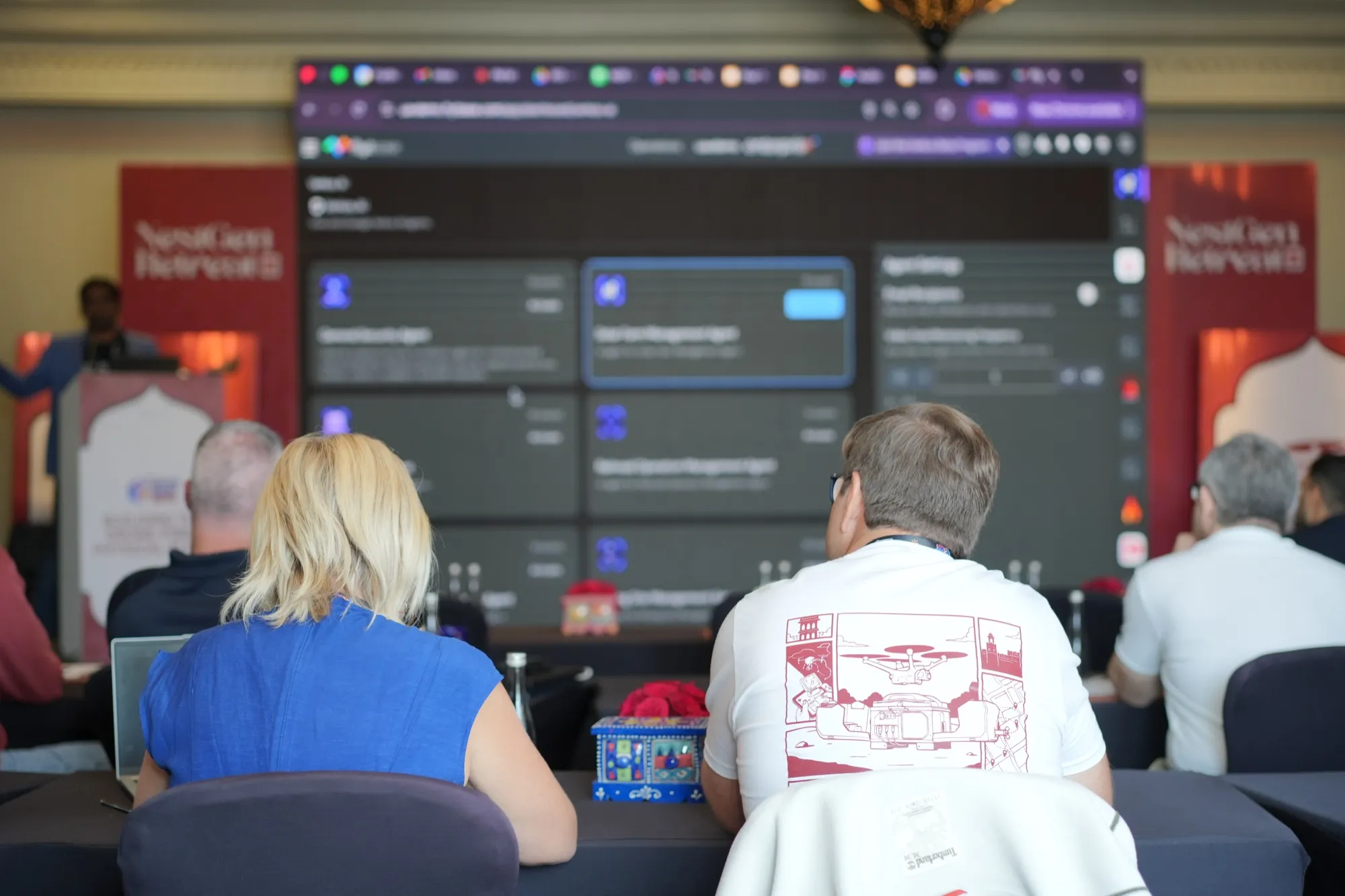 Guests watching a live AI tool demo on the big screen