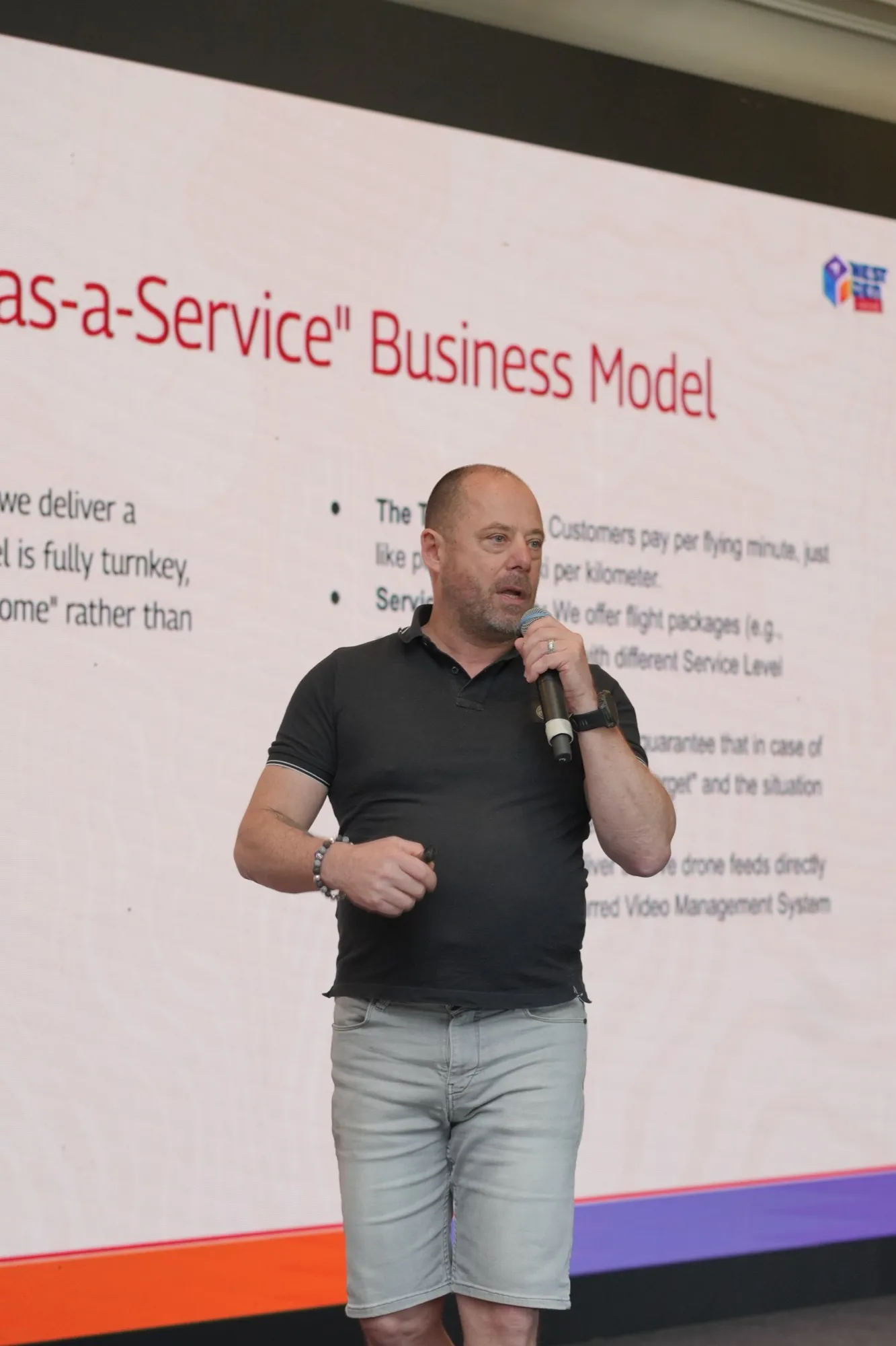 A pioneer speaking in front of a slide on the as-a-service business model