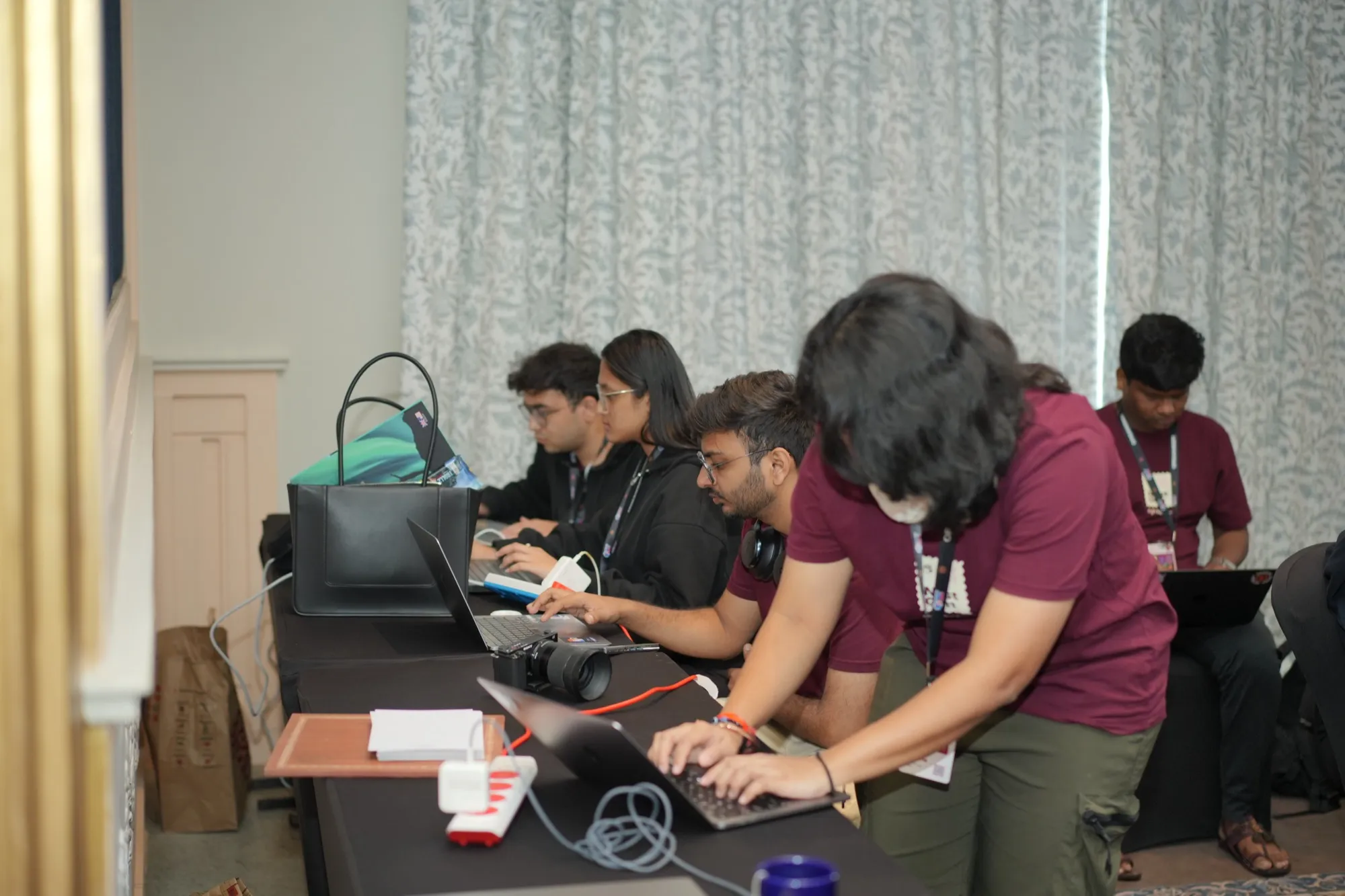 FlytBase team members at their laptops on the side of the Forum room