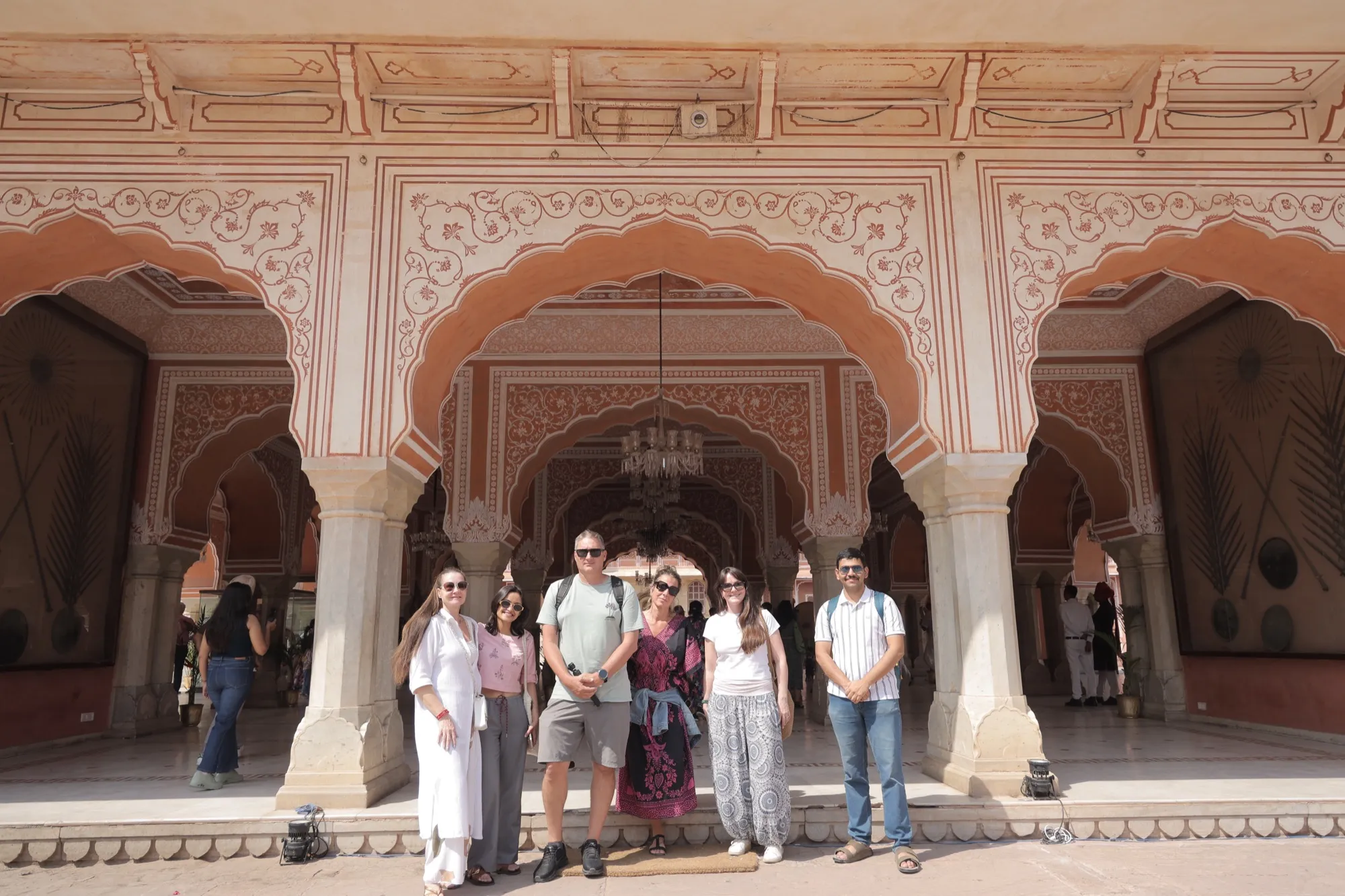 A group of guests under the carved arches of the City Palace