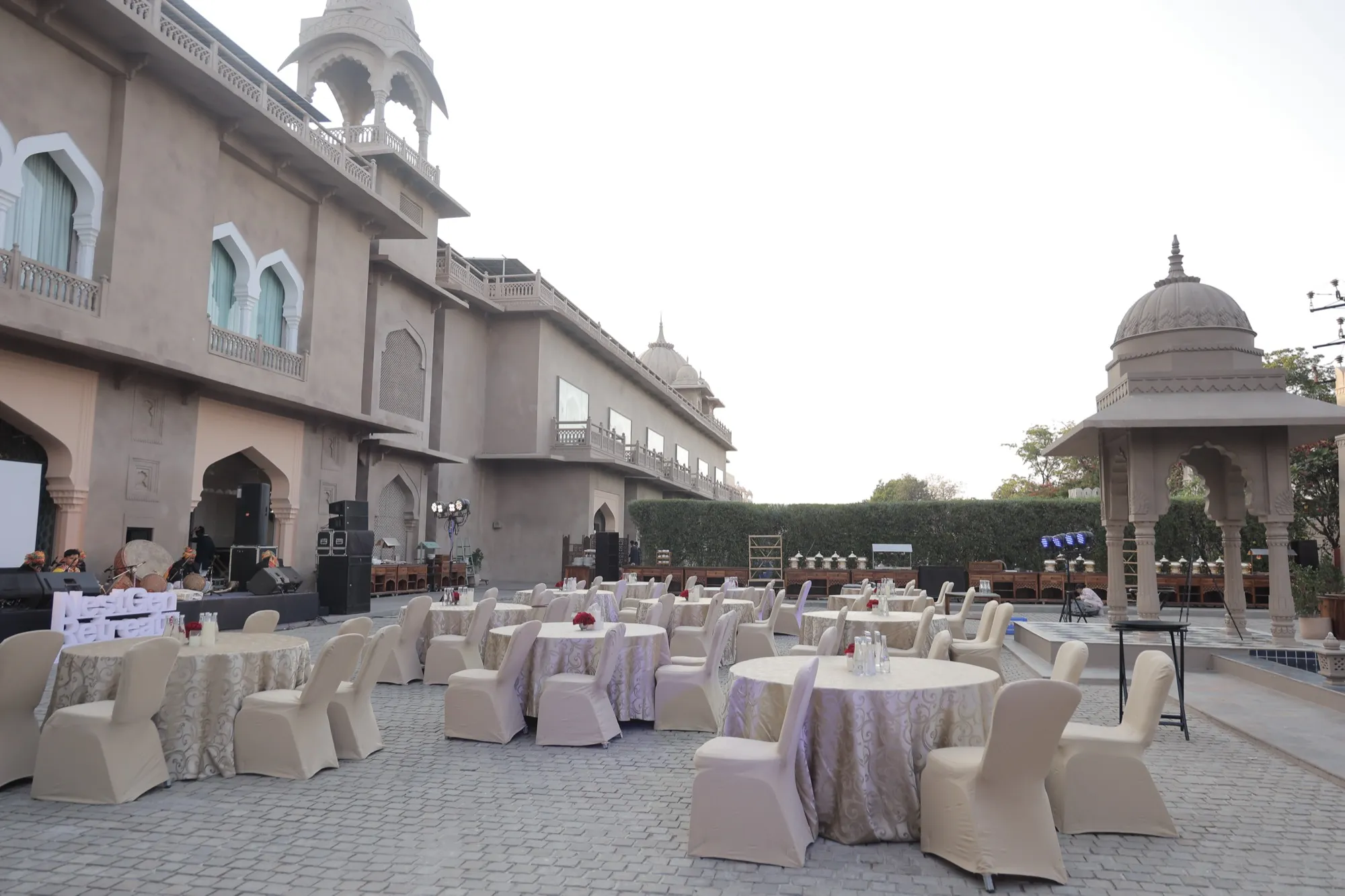 The palace courtyard laid with round tables, a domed pavilion at its edge