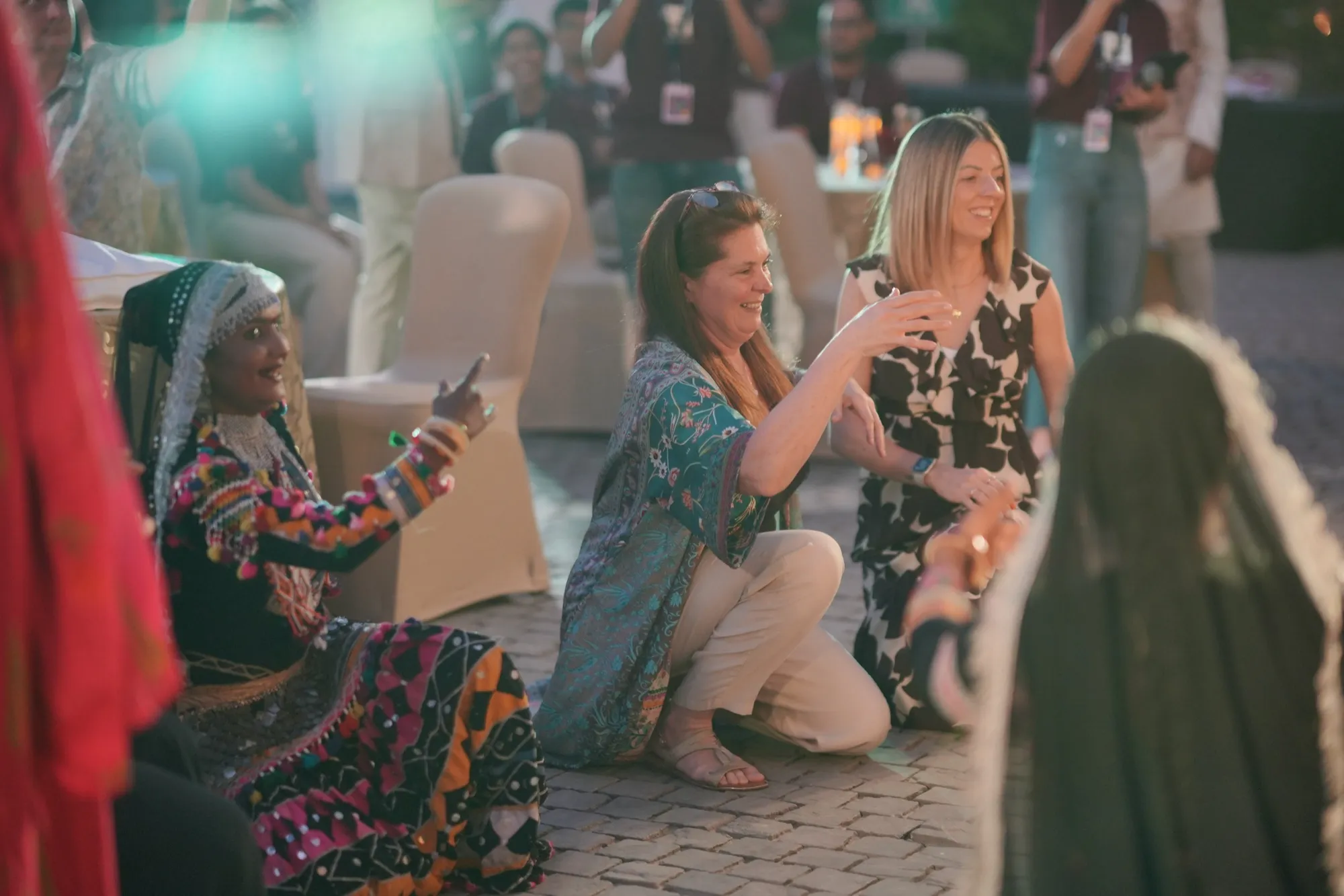 A dancer teaching two guests her steps beside their table