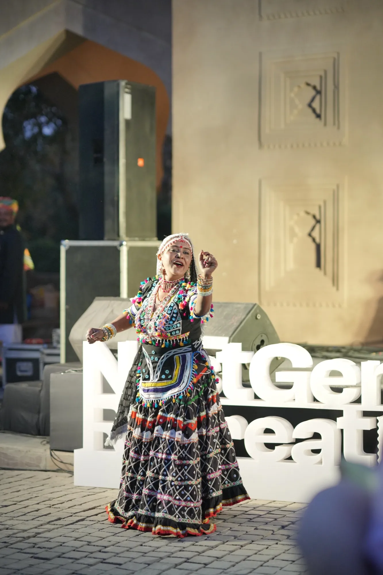 A Kalbeliya dancer in front of the NestGen Retreat sign