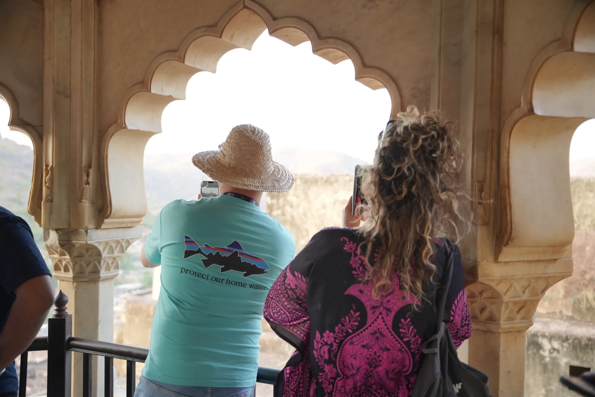 Two guests looking out over the hills through a scalloped window