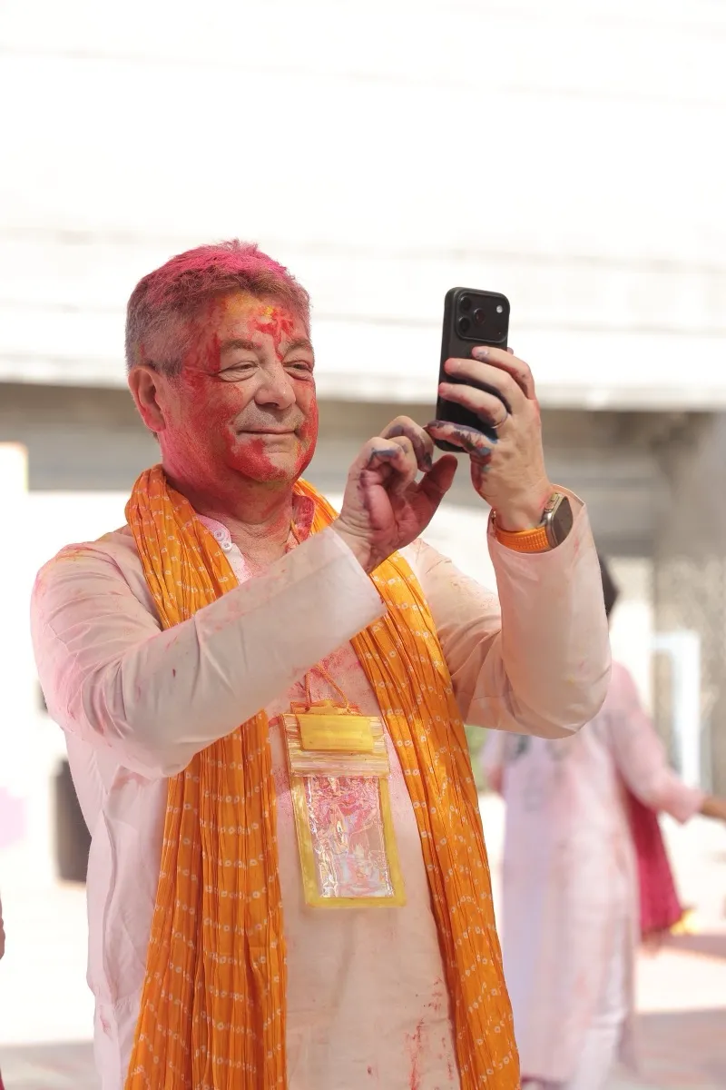 A guest with a colour-dusted face taking a photo