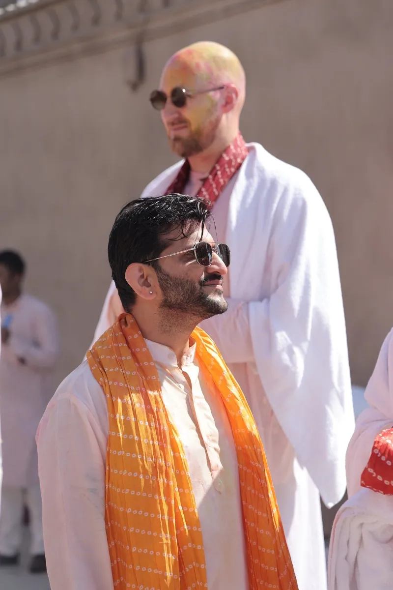Two guests in orange dupattas and sunglasses, laughing