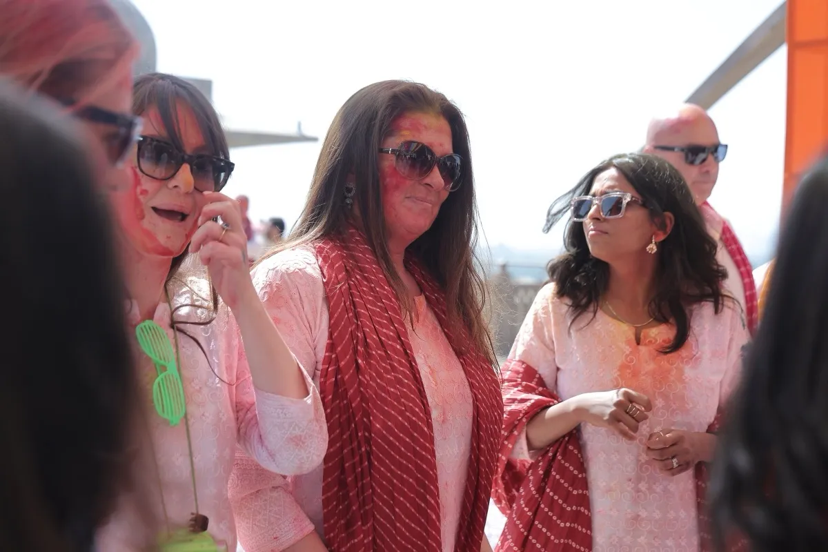 Three guests in sunglasses and bandhani dupattas sharing a joke