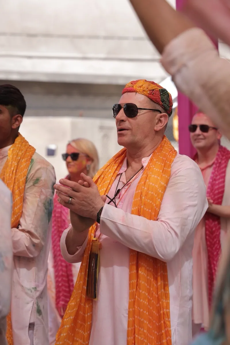 A guest in a red turban and an orange dupatta