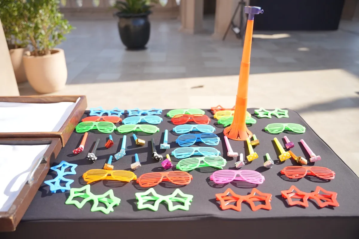 Coloured glasses and party sunglasses laid out on a table for Holi