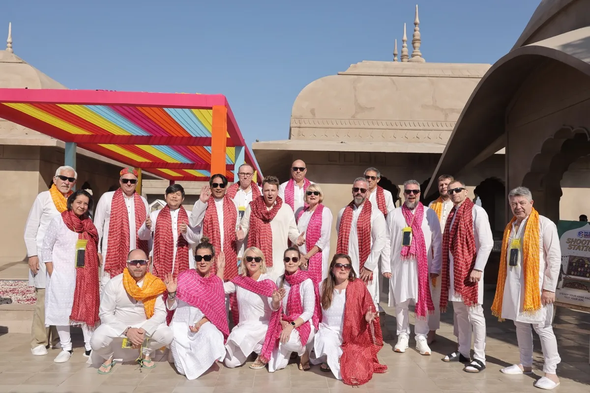 The pioneers posed in white kurtas and red dupattas under the rainbow canopy