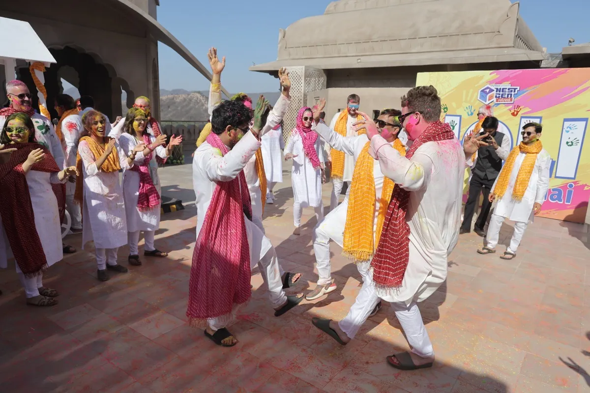 Guests dancing on the rooftop in white and red, colour in the air