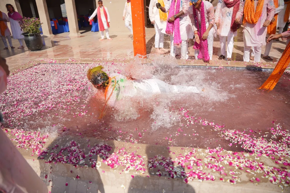 A guest diving into the shallow pool of water and rose petals