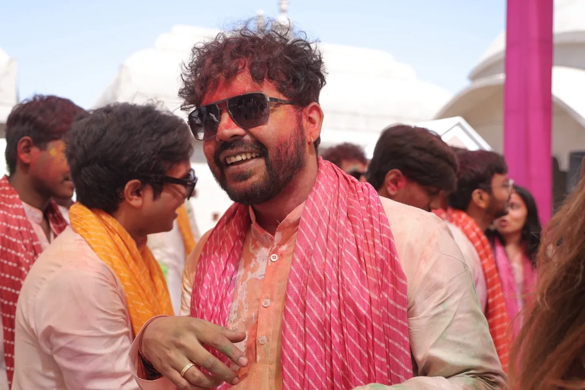 A guest with colour in his hair laughing among friends