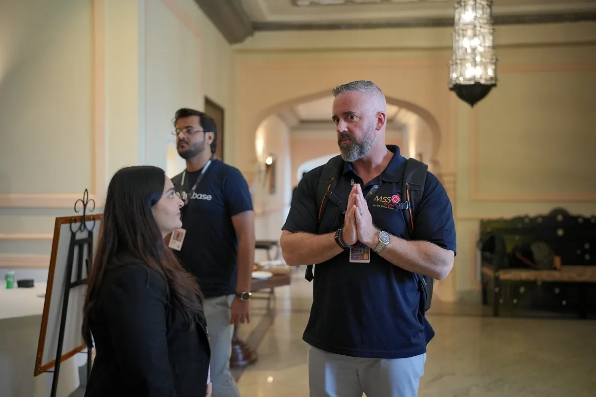 A pioneer greeting the FlytBase team with folded hands in the hotel lobby