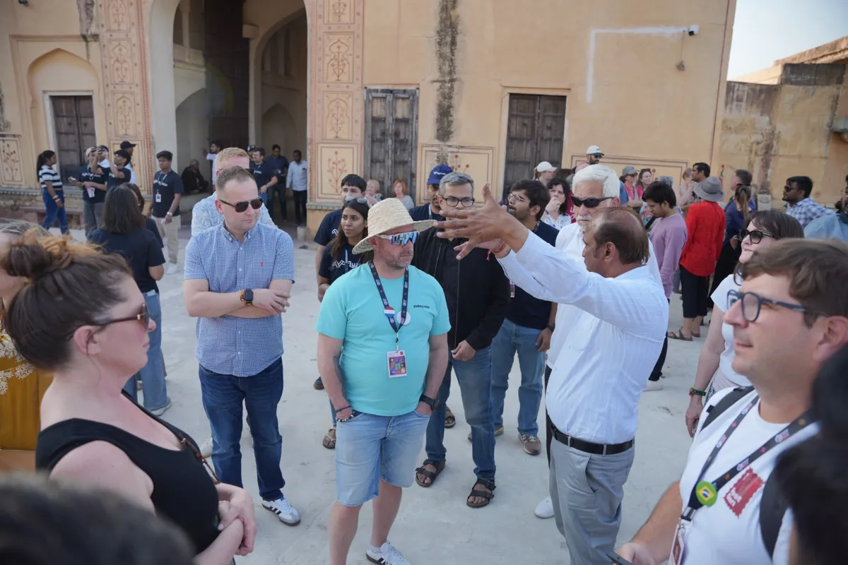 A guide pointing out the fort to a crowd of guests at Amer Fort