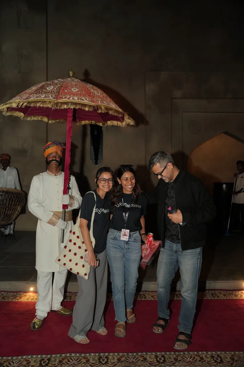 A guest welcomed back with a ceremonial umbrella at the hotel at night