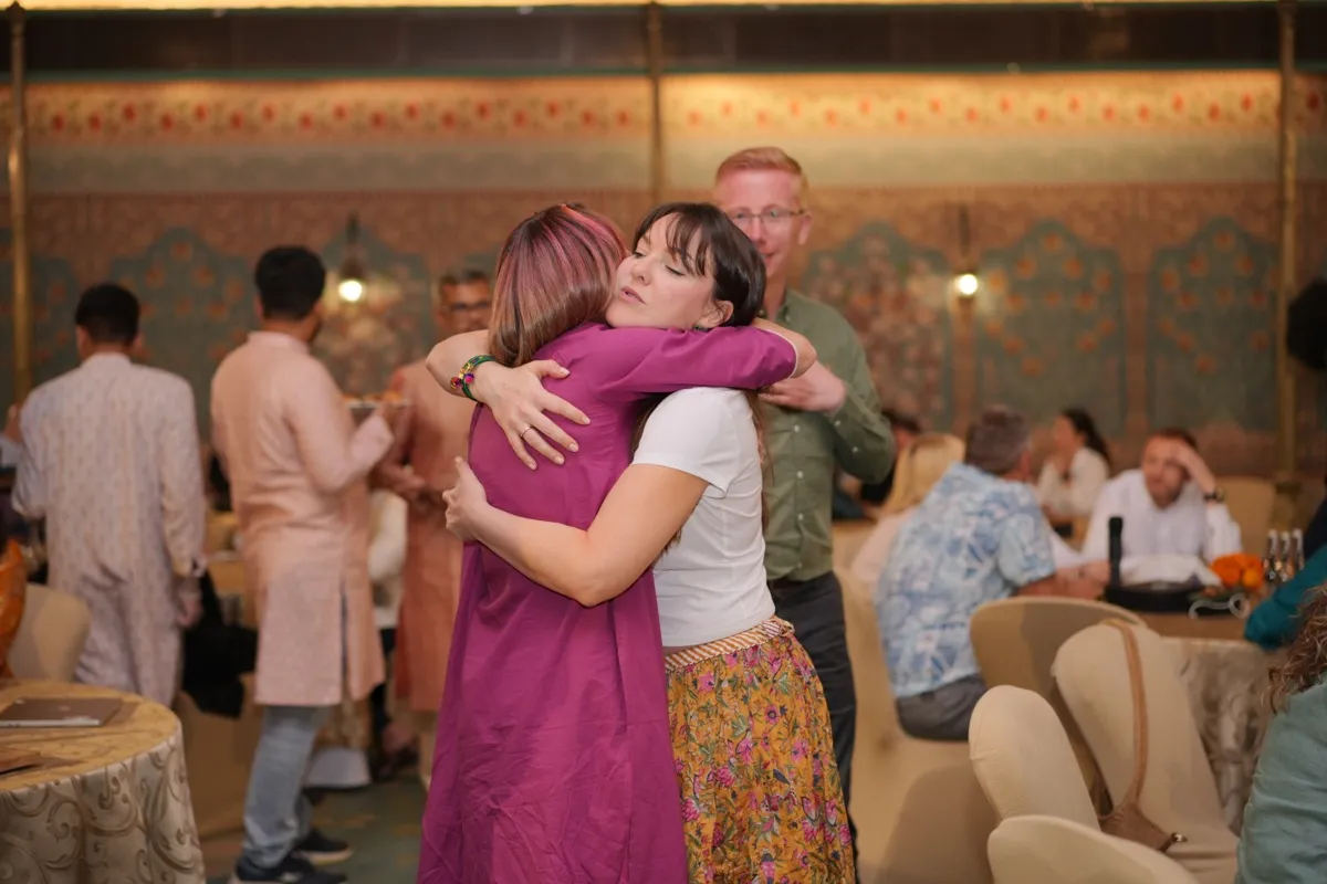 Two guests hugging goodbye in the painted hall