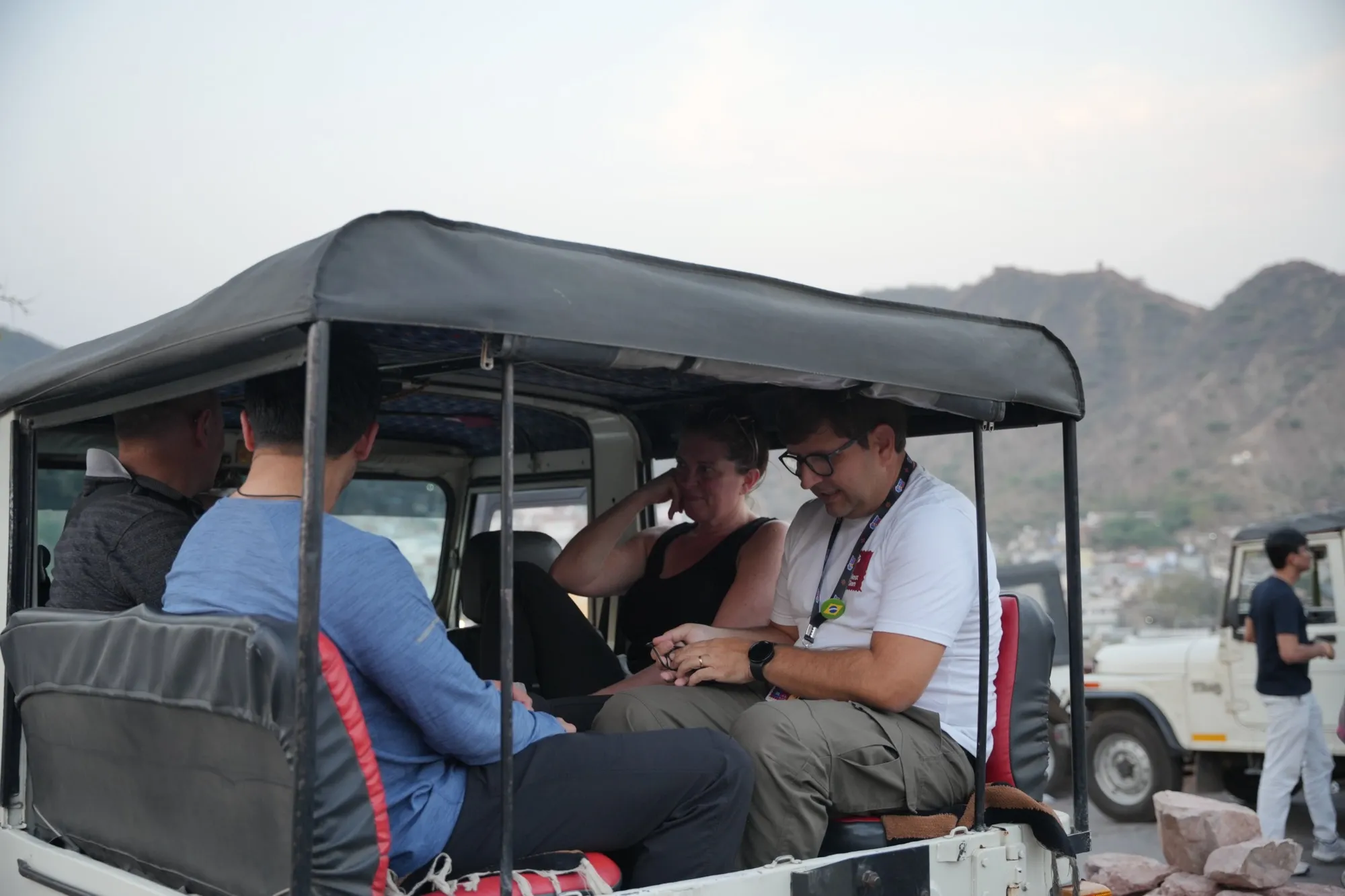Guests in an open jeep with the hills behind
