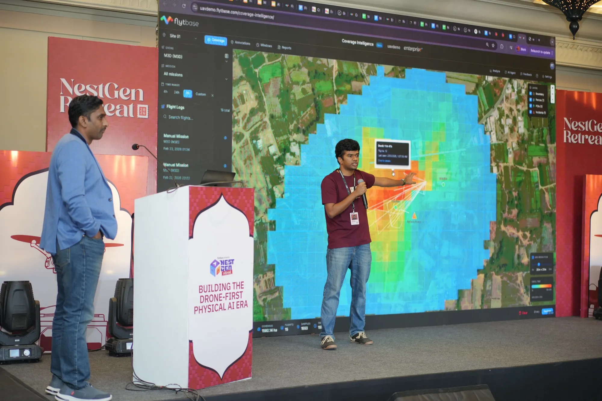 A presenter in front of a large coverage heat map on the screen