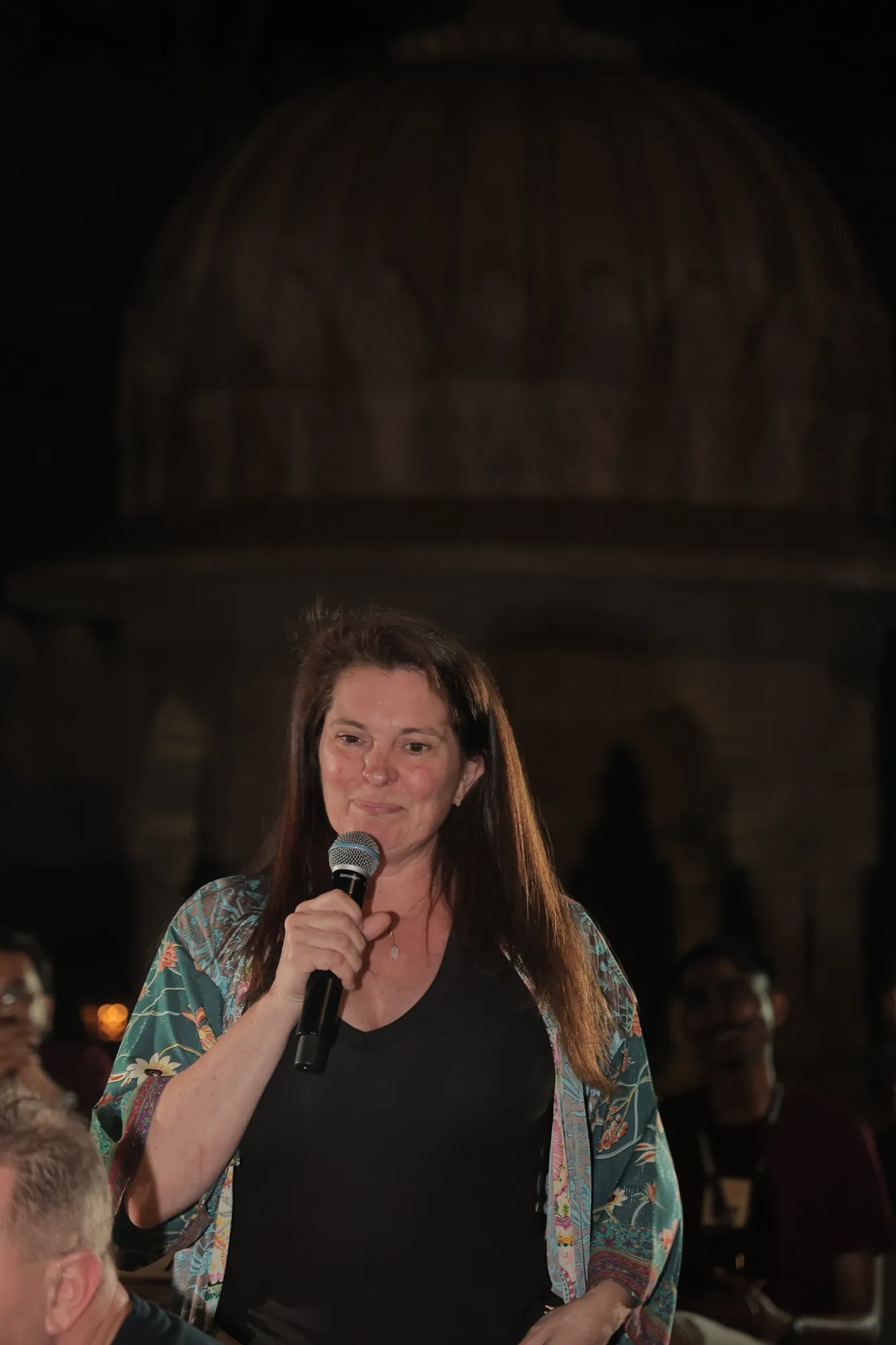 A pioneer introducing herself into a microphone under the night sky
