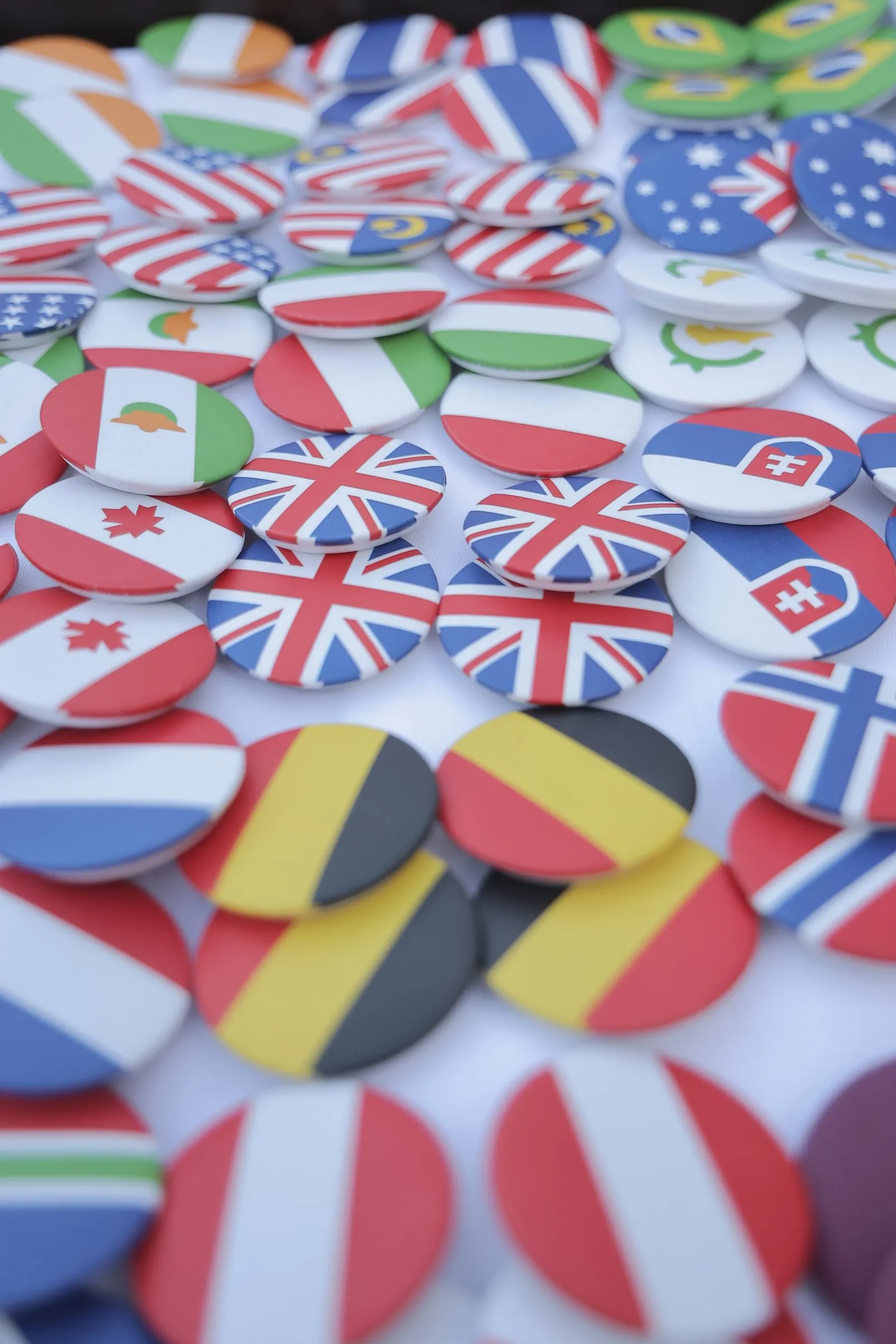 A pile of round pin badges printed with the flags of the guests' countries