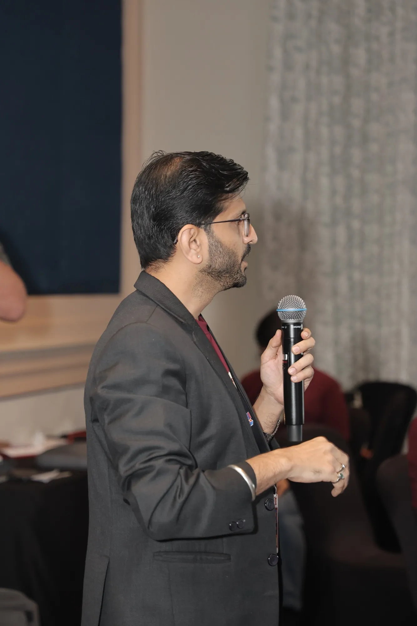 A guest standing with a microphone, asking a question
