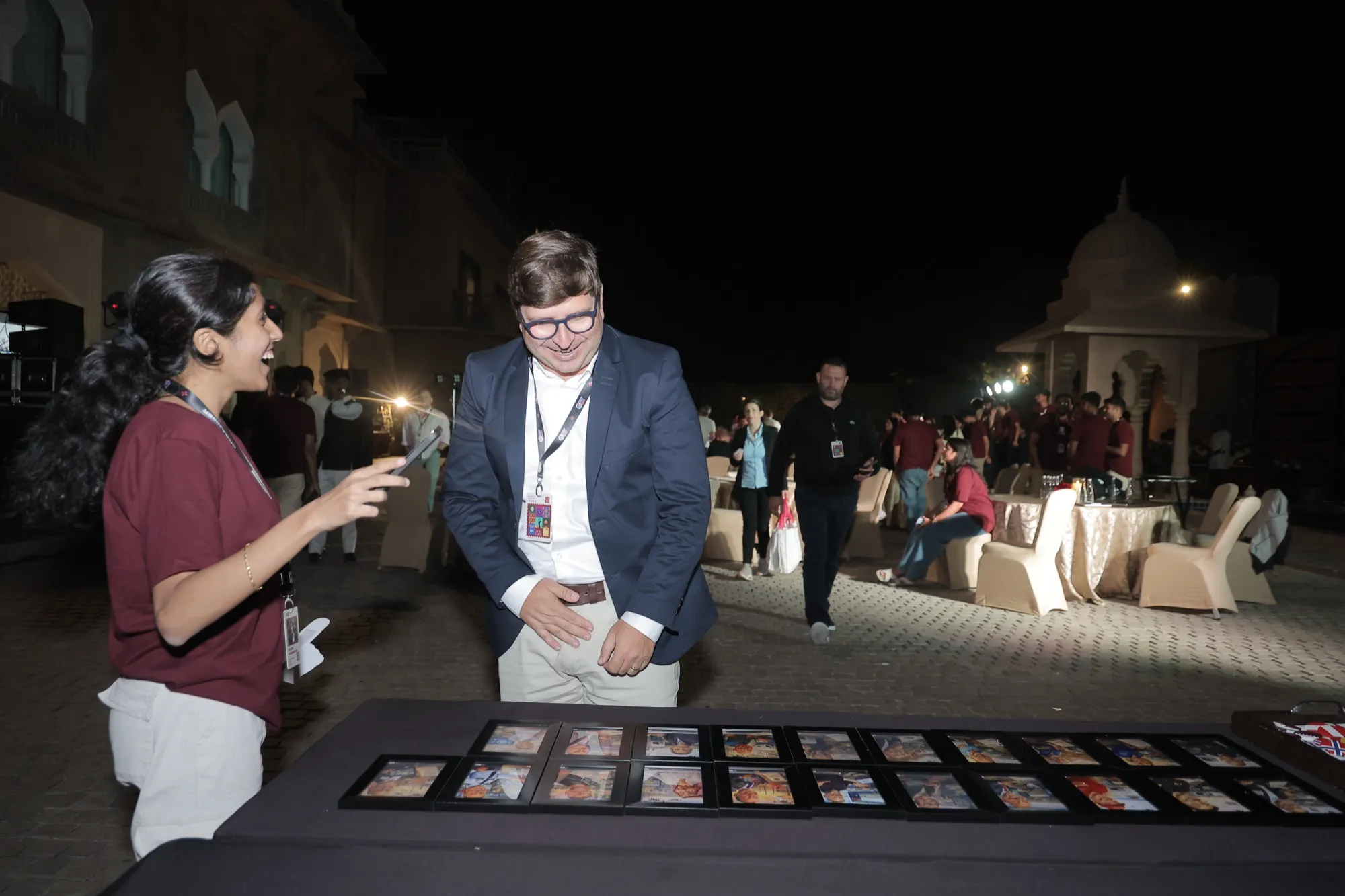 A guest choosing a stamp at a table of NestGen stamps at night